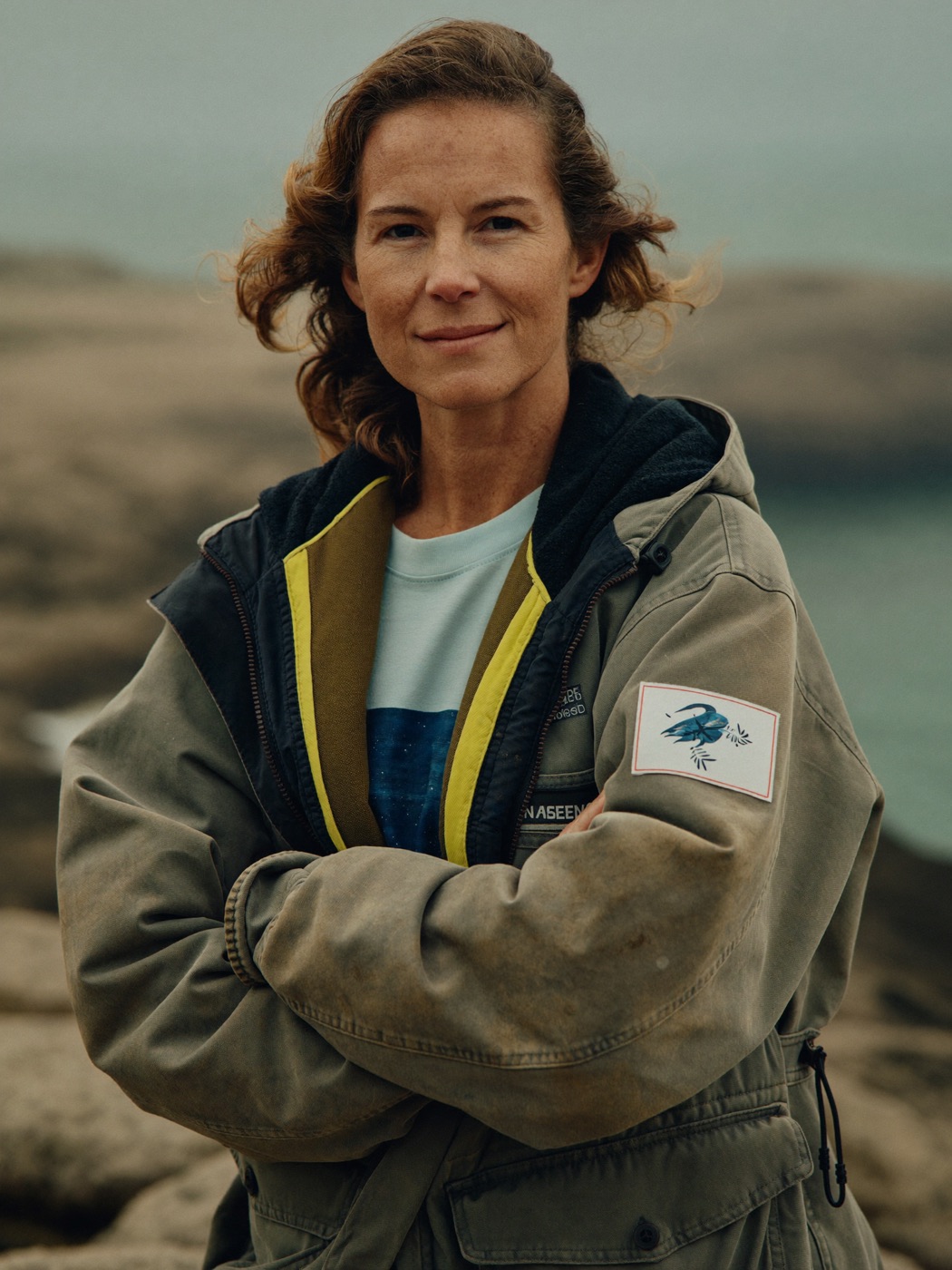 Portrait of Dr. Elena Marsh on a rocky coastline